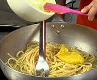 Con la pasta en la sartén vertemos la crema de huevo y queso para terminar con la receta de la salsa carbonara